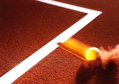 Highspeed - Tennisball beim Einschlag auf einem Sandplatz